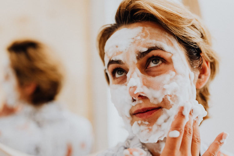 Primer plano de mujer aplicando limpiador facial en espuma