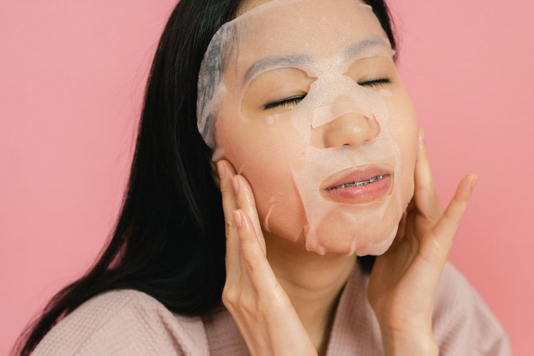 Mujer aplicando una mascarilla facial de tela hidratante